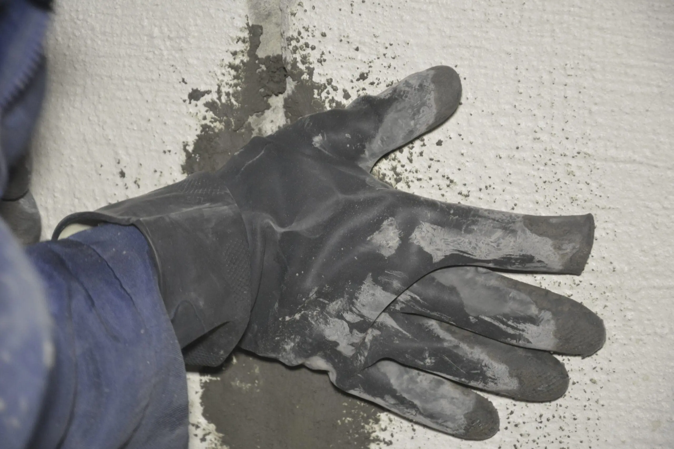 Рука що тримає гідропломбу в тріщині в стіні, звідки було активне протікання води