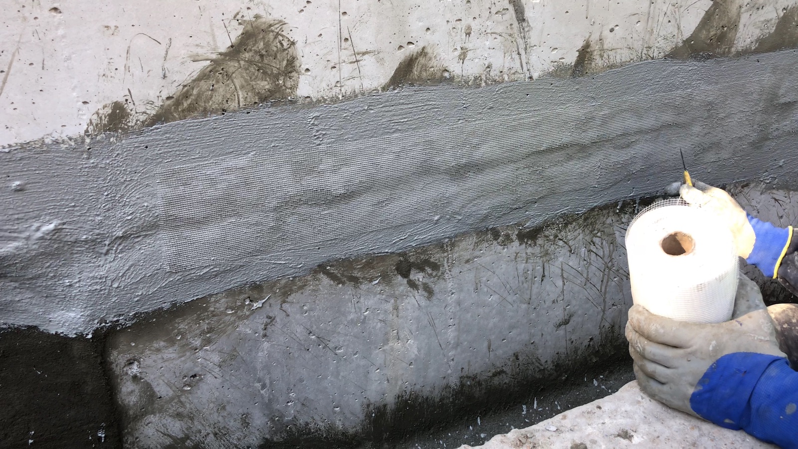 Армування склосіткою першого шару еластичної гідроізоляції на міжблочних швах