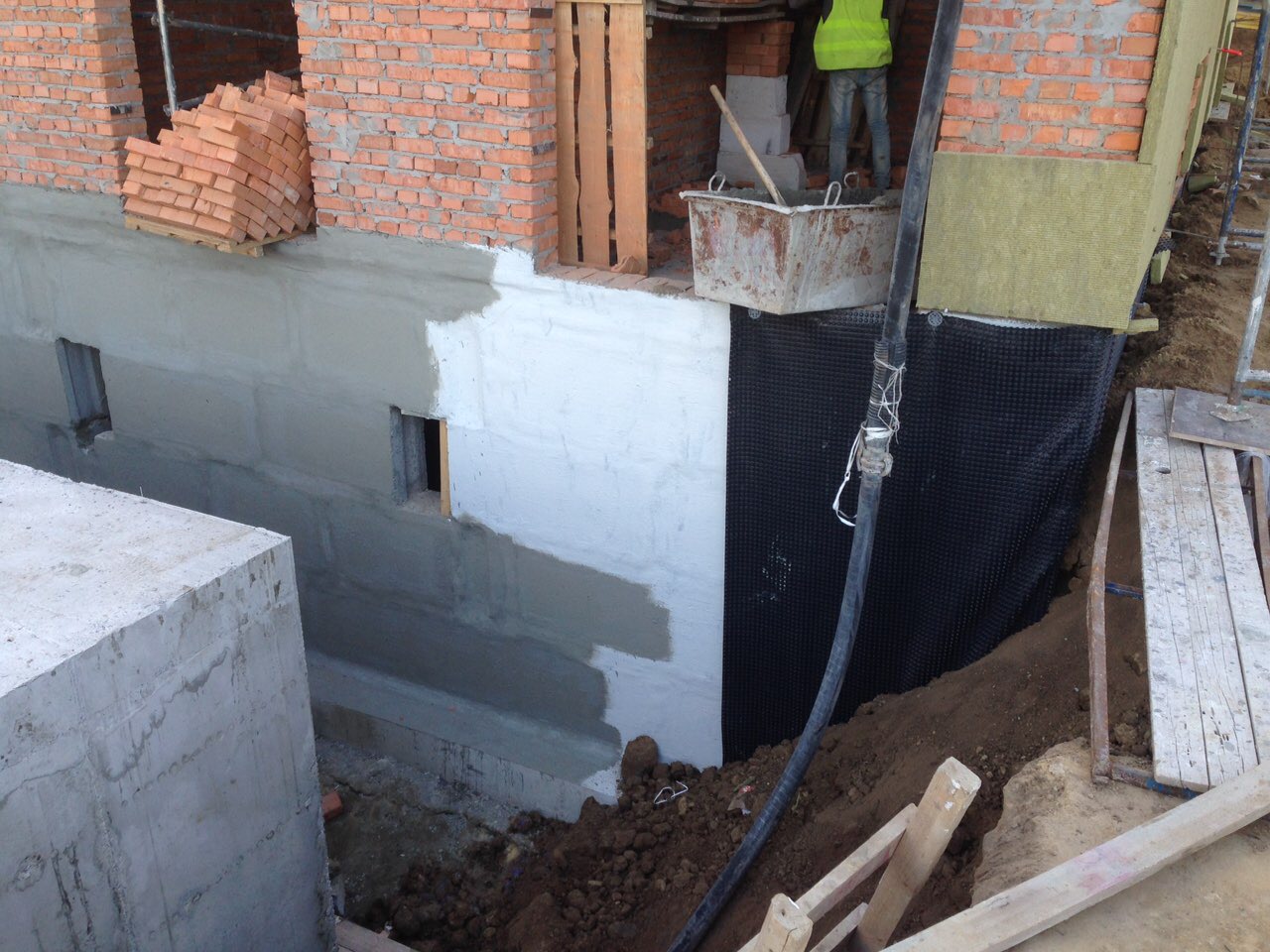Виконана гідроізоляція ззовні стін фундаменту у 2 шари білого та сірого кольору та подальшим захистом дренажною мембраною
