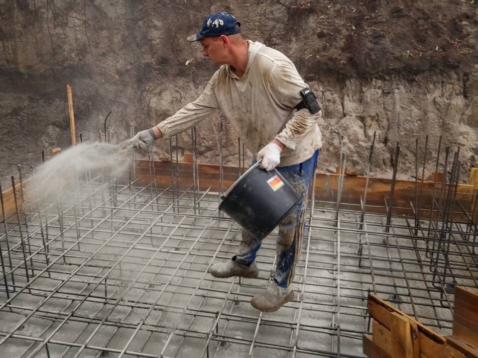Працівник розсипає порошок KRYS Premium на арматурний каркас