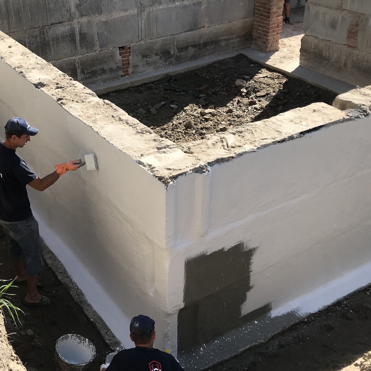 Процес нанесення гідроізоляції фундаменту з блоків ФБС